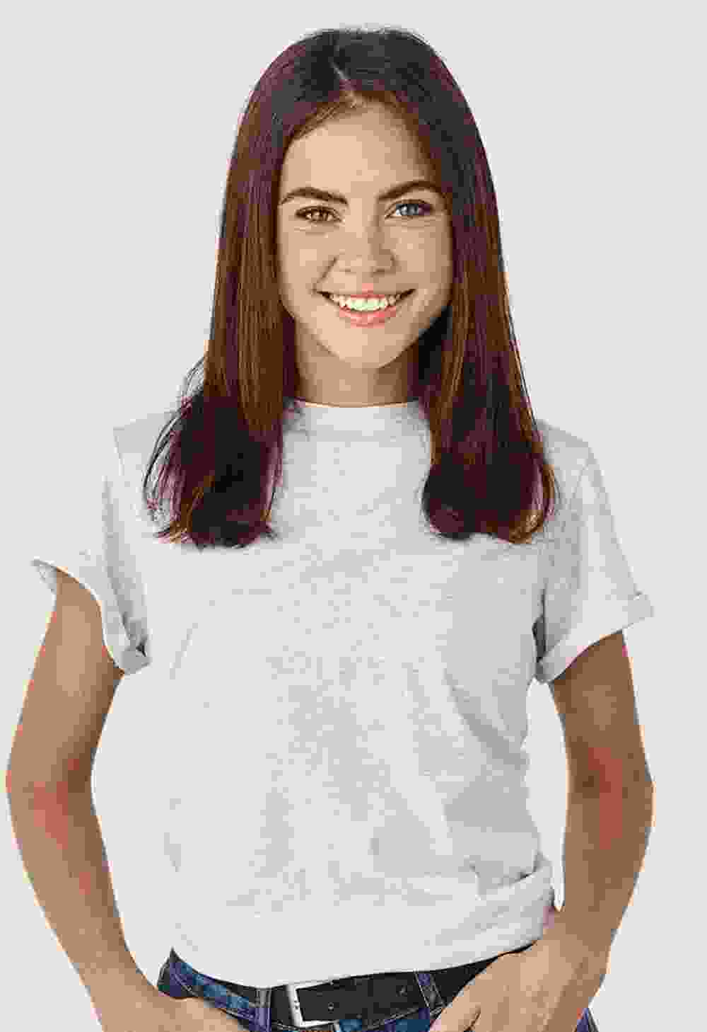 Smiling young woman in a white t-shirt and jeans against a plain background.