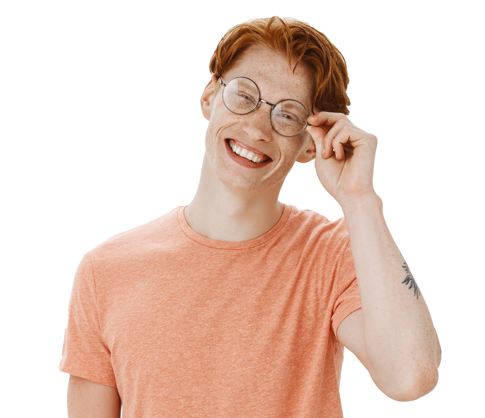 Smiling young man with red hair and glasses wearing a peach t-shirt.