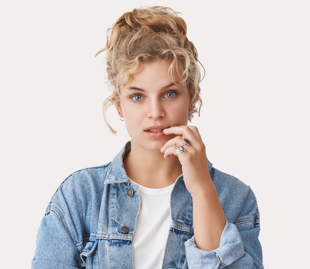 Portrait of a thoughtful young woman in a blue denim jacket.