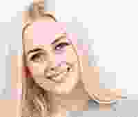 Smiling woman with blonde hair and flawless skin.