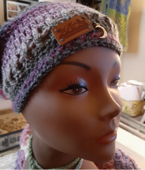 Close-up of a mannequin wearing a knitted beanie with a leather tag.