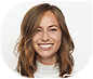Smiling young woman with light brown hair in a white sweater.