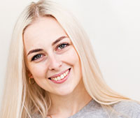 Smiling young woman with long blonde hair and light makeup.